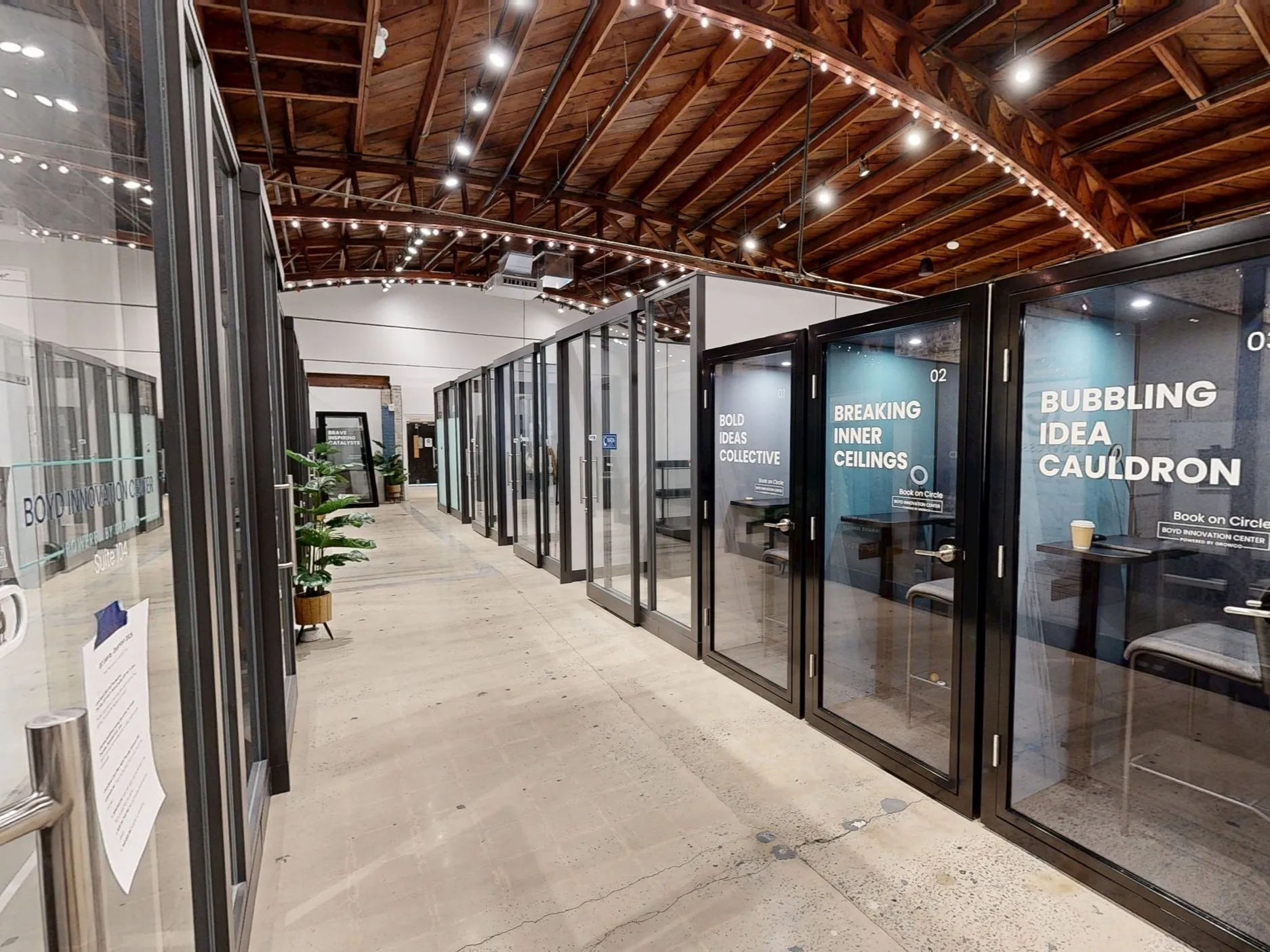 Glass-walled meeting rooms named Bold Ideas Collective and Breaking Inner Ceilings inside Boyd Innovation Center coworking space in Columbia SC